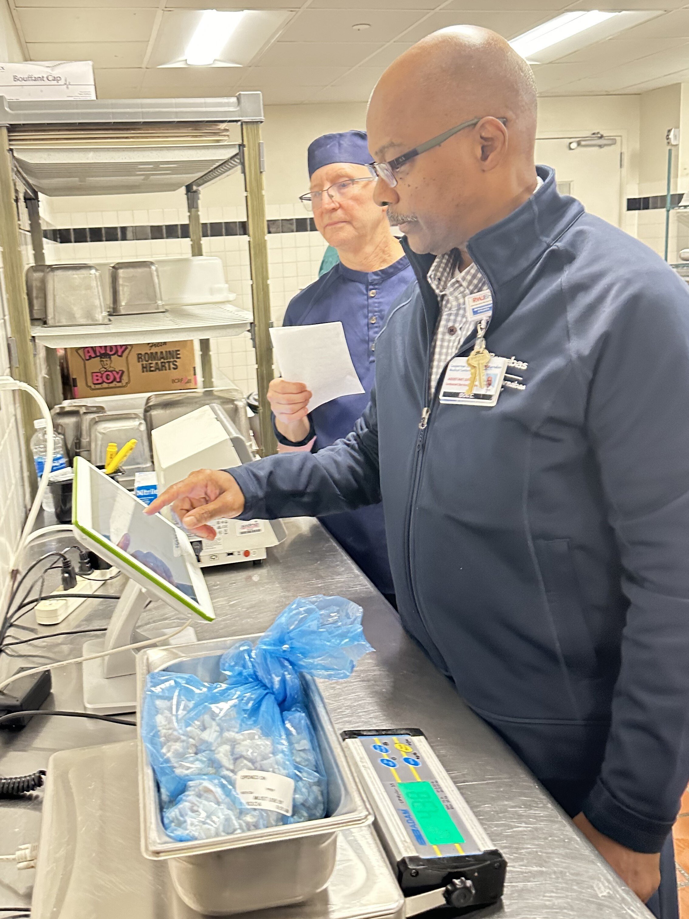Hospital foodservice manager logging a bag of food waste on the Leanpath tracker touchscreen